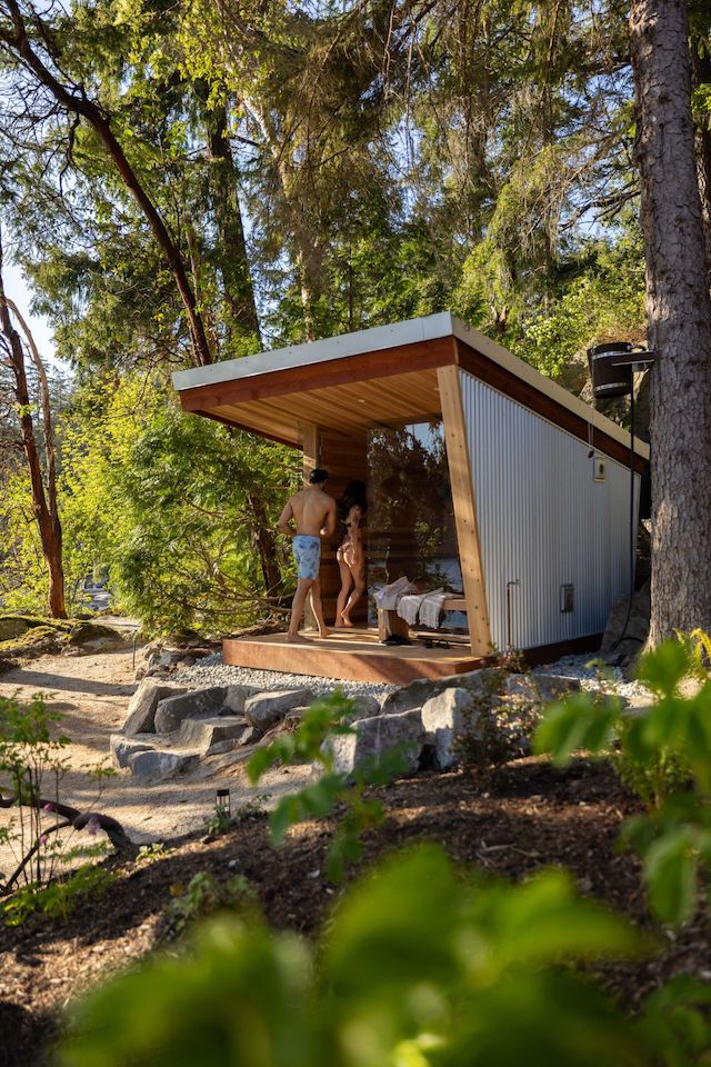 couple entering custom cedar sauna built into the landscape
